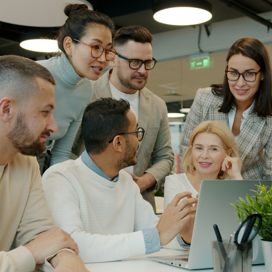 A team working together around a laptop
