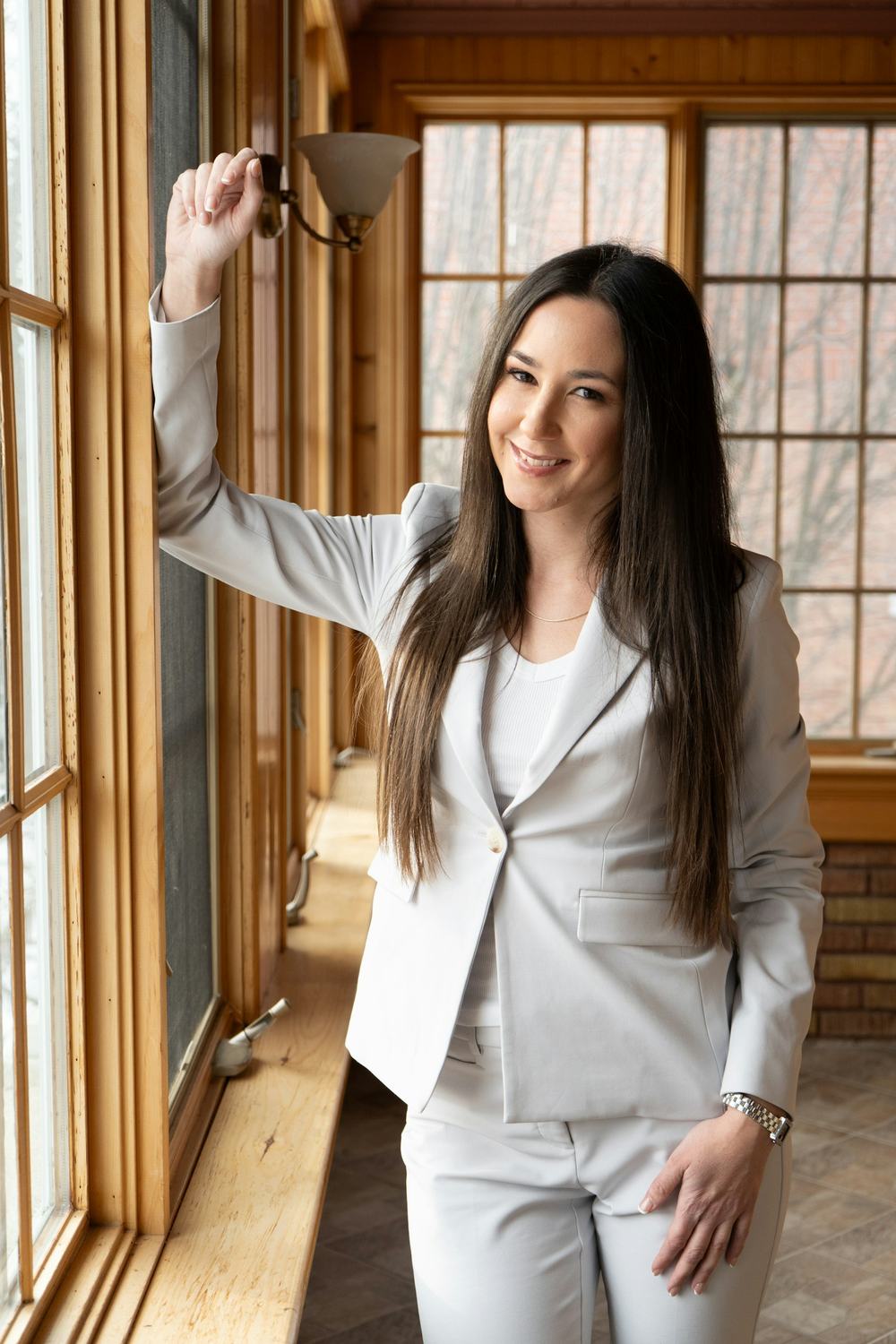 A smiling advisor standing by a window