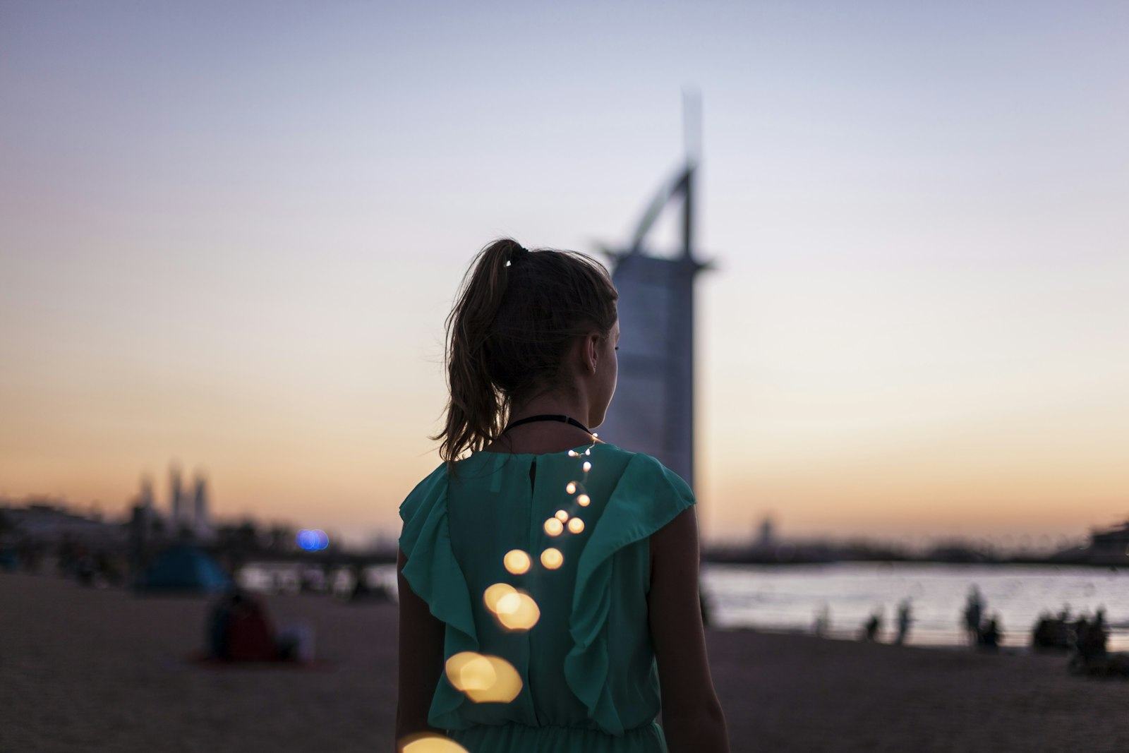 A girl on the beach near the Burj Al Arab at golden hour